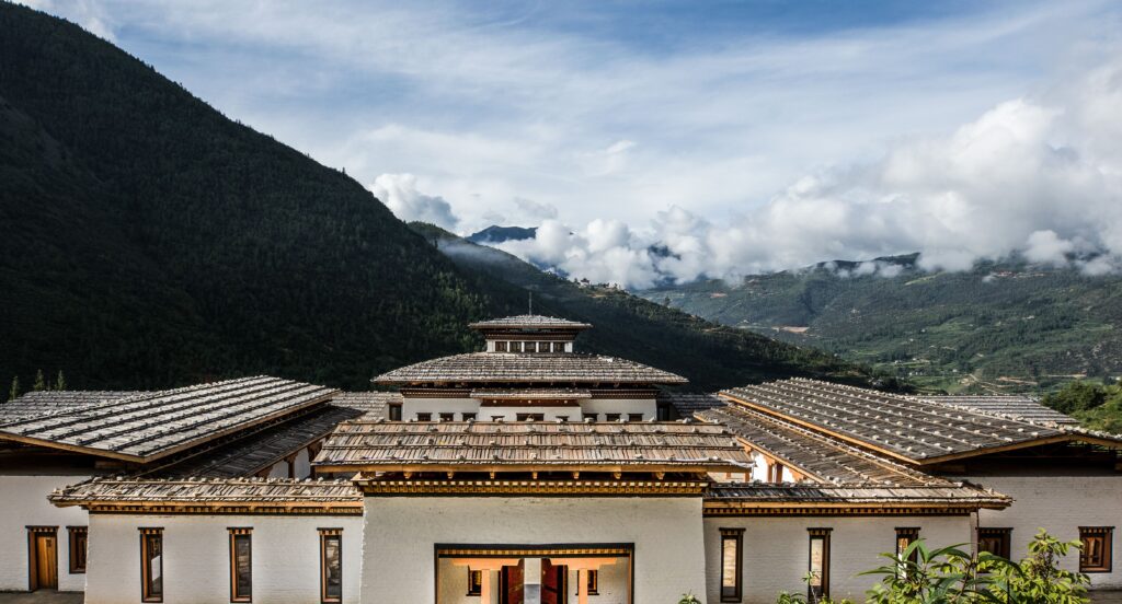 bhutan spirit sanctuary building with a roof and mountains in the background