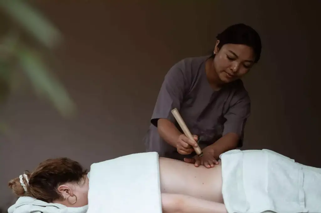 a woman using a tool to massage a woman's back