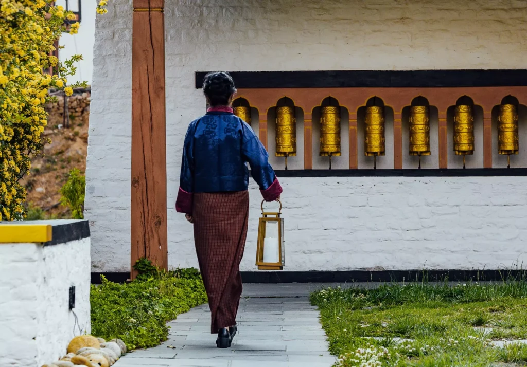 a woman walking down a path with a lantern