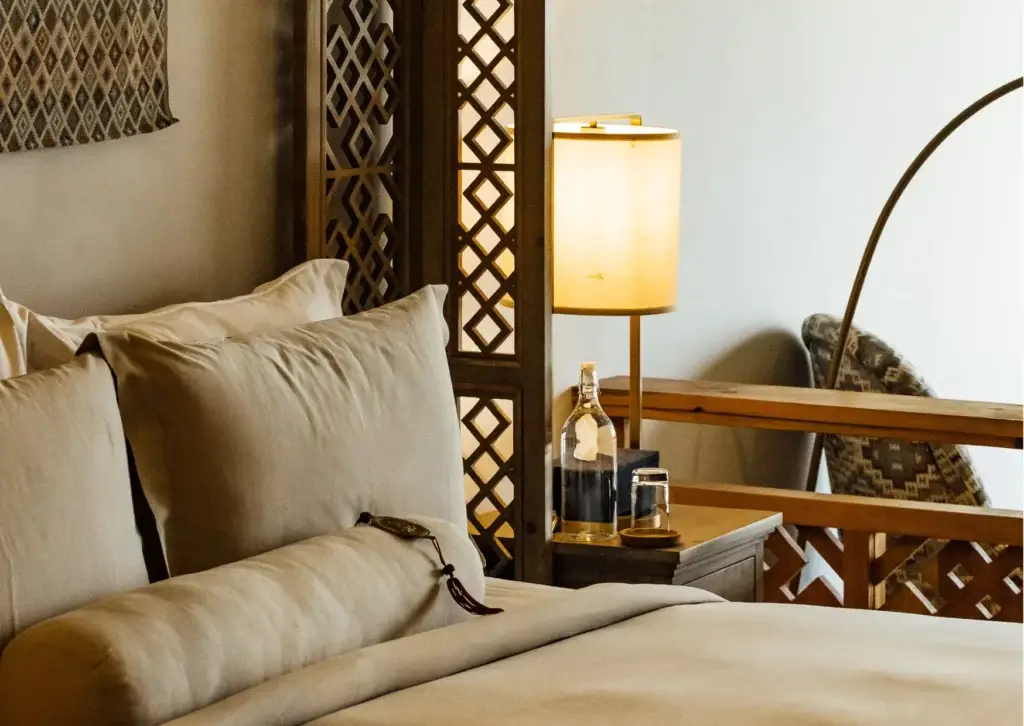 a bed with pillows and a lamp in bhutan spirit sanctuary