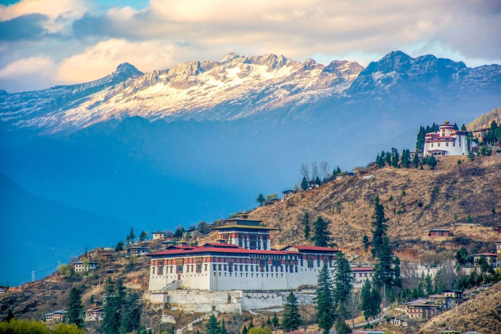 a building on a hill with mountains in the background