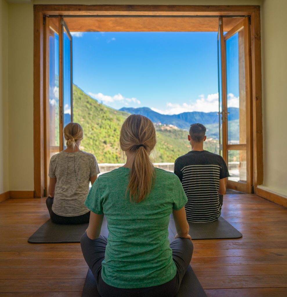 a group of people sitting in a room with a window open