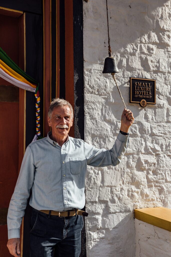 a man holding a bell outside Bhutan Spirit Sanctuary
