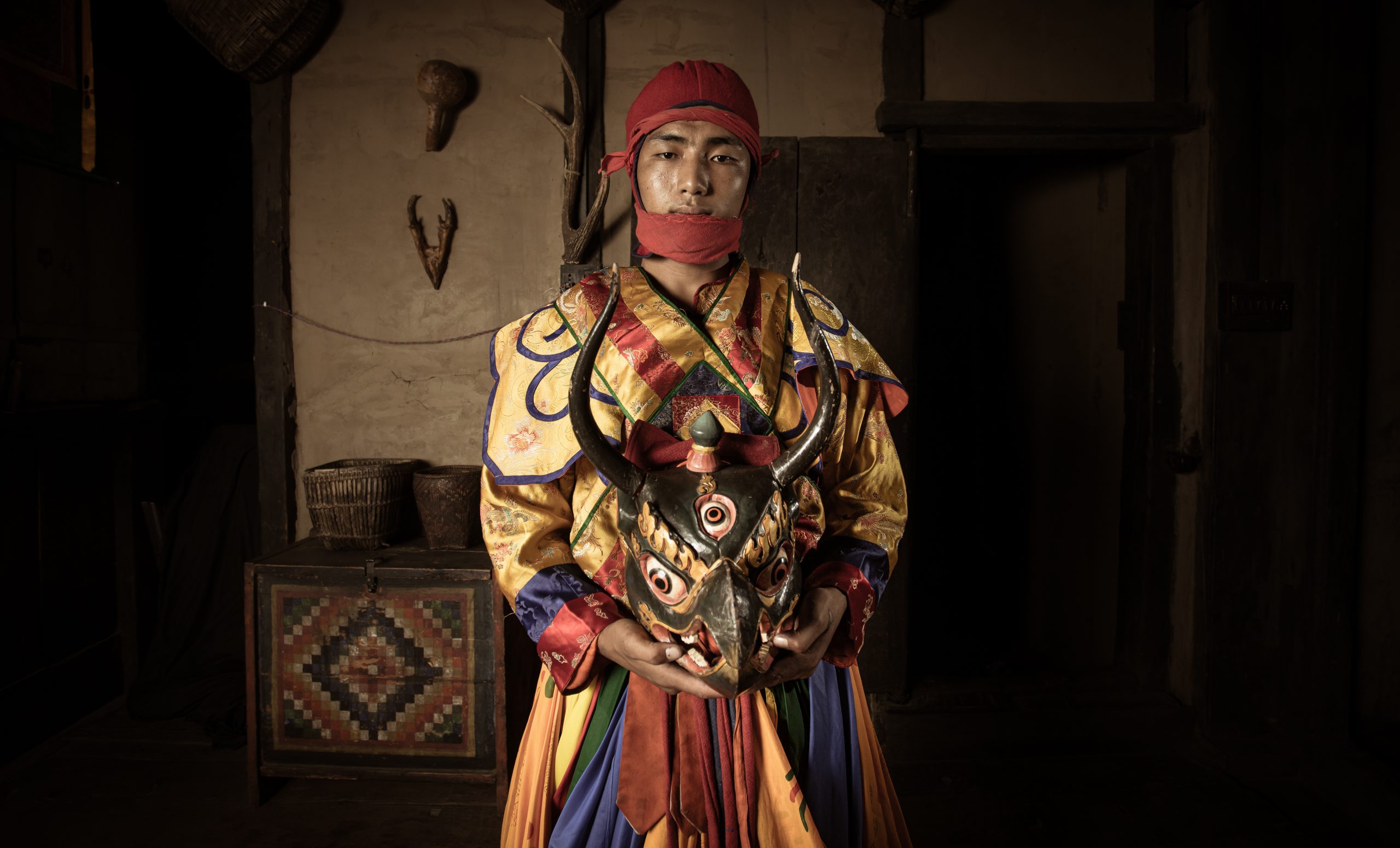 a man in a garment holding a mask