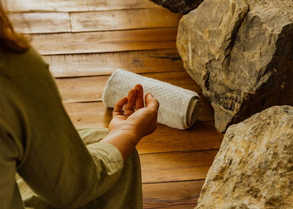 a person sitting on the floor with a rolled up towel