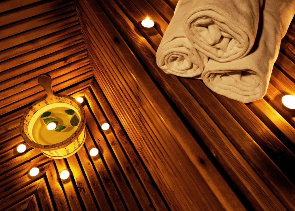 a candle and towels on a wooden surface
