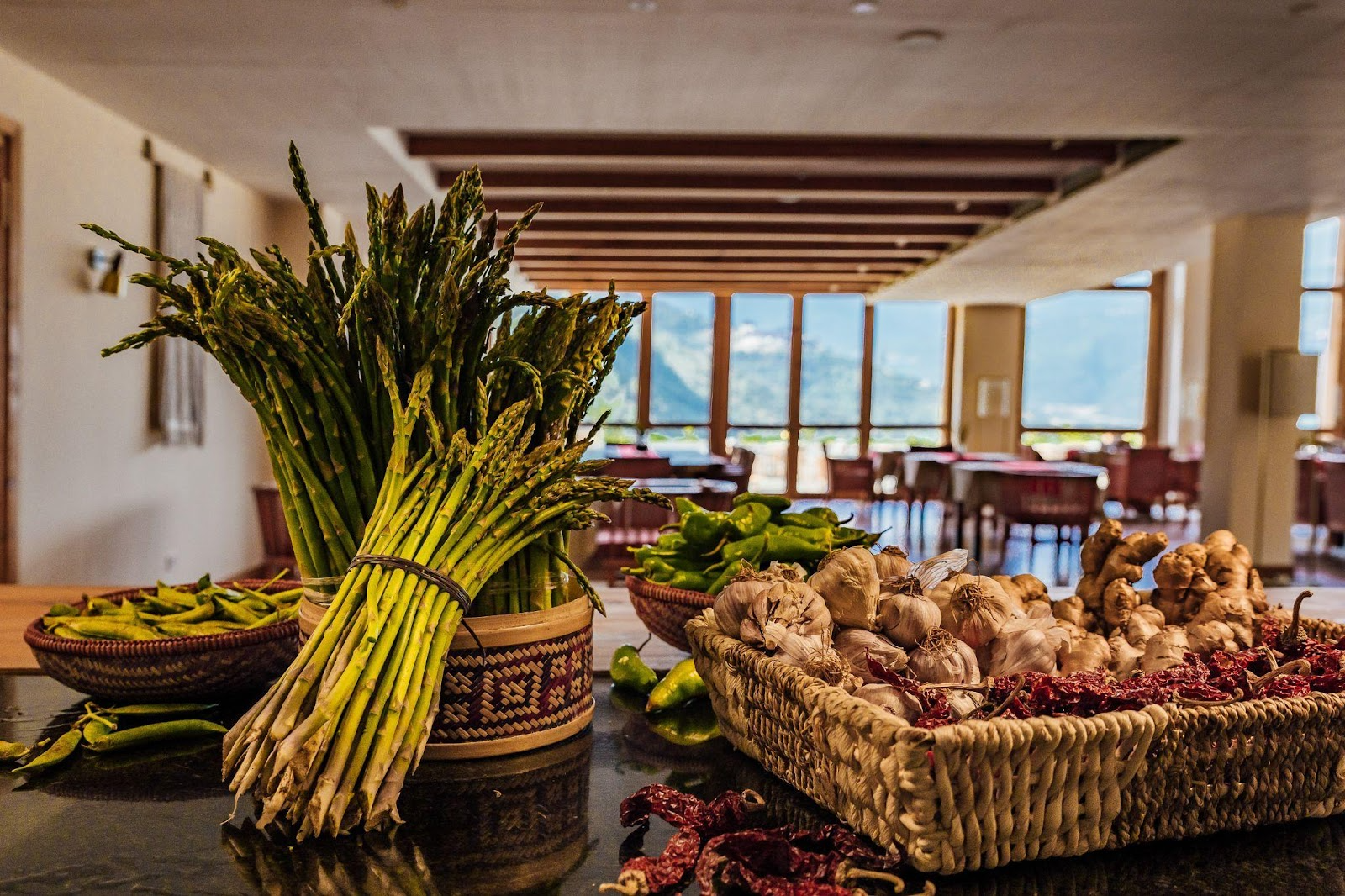 vegetables spread out on a table next to basket with garlic